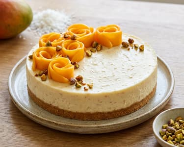 Kokos-Cheesecake mit Mango und karamellisierten Pistazien